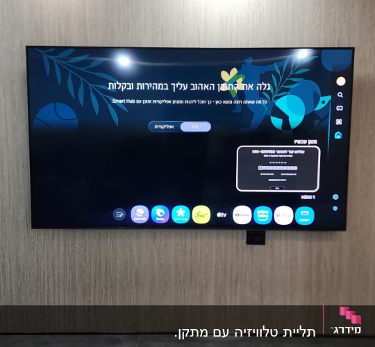 מסך טלוויזיה מותקן על קיר עם תצוגה דיגיטלית